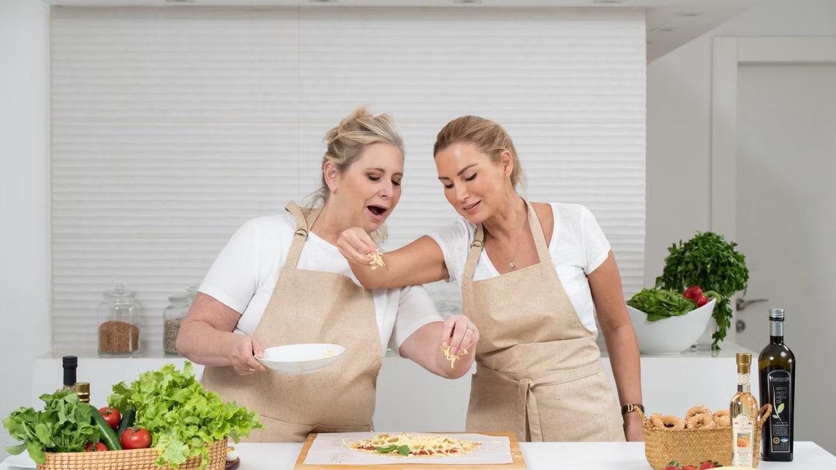 Two women preparing a delicious meal with fresh ingredients in a modern kitchen.
